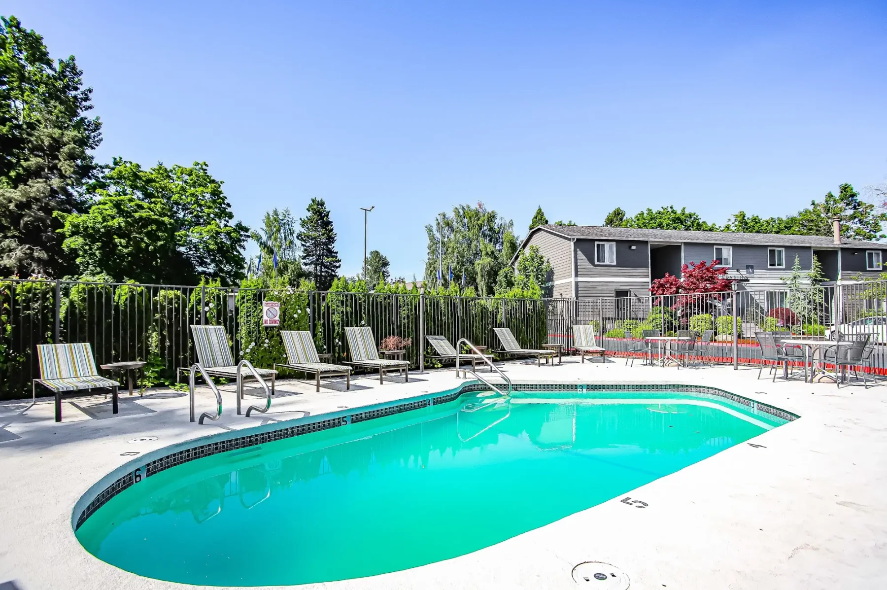 Irwin Park swimming pool with poolside lounge seating.