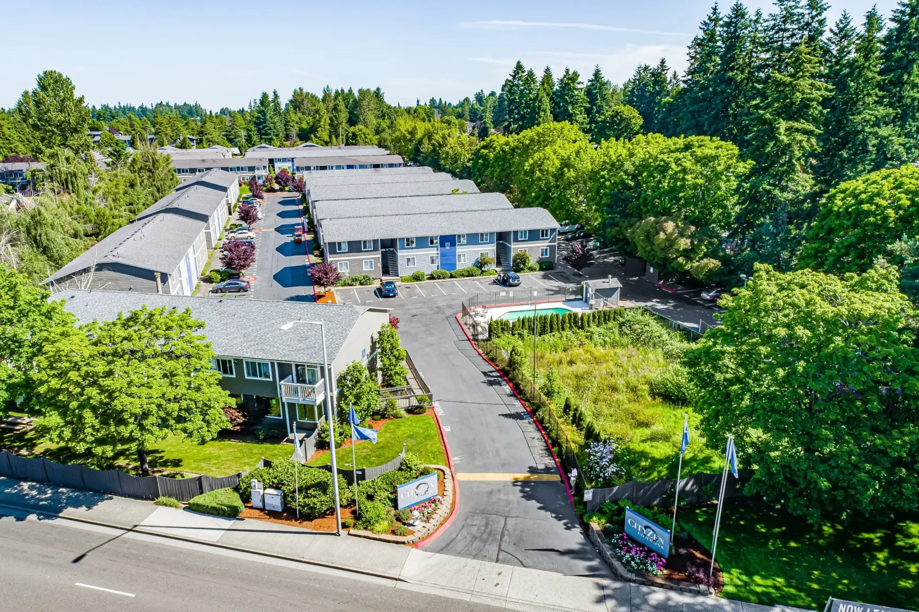 Irwin Park community entrance. Community buildings surrounded by lush trees and greenery.