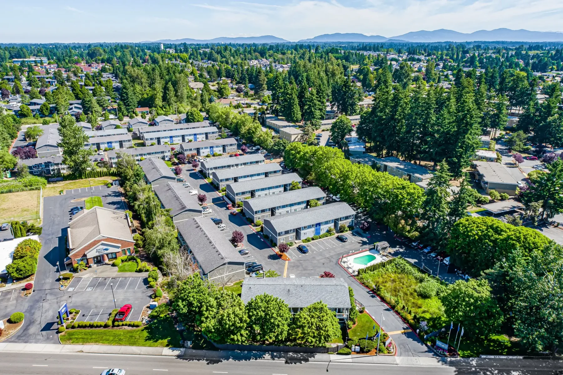 Irwin Park community entrance. Community buildings surrounded by lush trees and greenery.